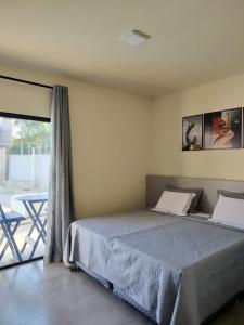 1 dormitorio con cama y ventana grande en Morada Stucchi, en Balneário Camboriú