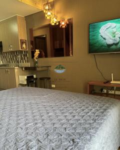un grande letto in una stanza con televisore a parete di Twin Lakes Tagaytay - Le Prin a Tagaytay