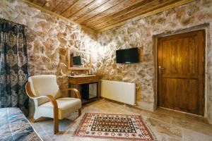a stone walled room with a chair and a desk at Tughan Stone House in Uçhisar