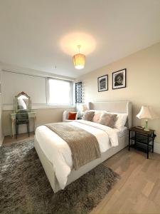 a bedroom with a large white bed and a window at Amazing view 2 bedroom in Abbey Road in London