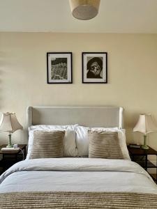 a bedroom with a bed with three pictures on the wall at Amazing view 2 bedroom in Abbey Road in London