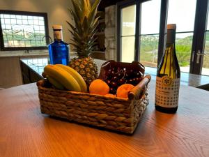 una cesta de fruta en una mesa con una botella de vino en Luxury Villa Girona Bellissimo, en Girona
