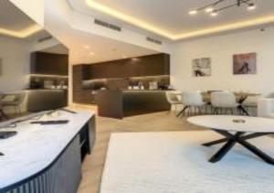 a living room with a table and chairs and a kitchen at Key View - Marina Torch in Dubai