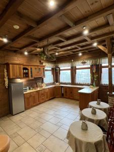 a kitchen with two tables and a refrigerator at Kapteinis&Grants in Engure