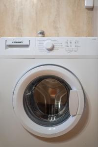a white washing machine with its door open at Kazamia Apartments with Sharing Pool in Agia Fotia