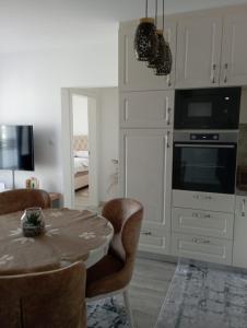 uma sala de estar com uma mesa e uma cozinha em Apartmani Dar Lux em Banja Koviljača