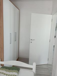 um quarto branco com um espelho e uma cama em Apartmani Dar Lux em Banja Koviljača