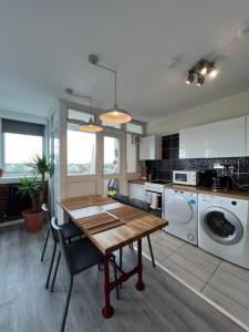 a kitchen with a table and a washing machine at Amazing view 2 bedroom in Abbey Road in London