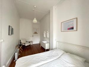 a white bedroom with a bed and a table at Hostel Alegria in Porto