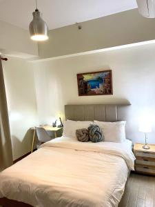 a bedroom with a large white bed and a desk at 1 Bedroom Condo near ICC Megaworld with netflix in Iloilo City