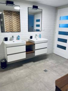 ein Badezimmer mit zwei Waschbecken und zwei Spiegeln in der Unterkunft Roubenka U 2 přátel in Pec pod Sněžkou