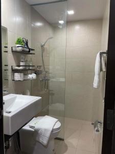 a bathroom with a shower and a toilet and a sink at 1 Bedroom Condo near ICC Megaworld with netflix in Iloilo City