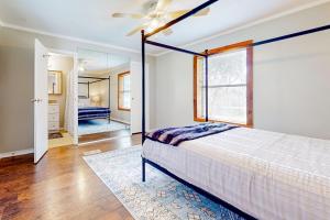 a bedroom with a bed and a ceiling fan at Slaughter Creek Cottage in Austin