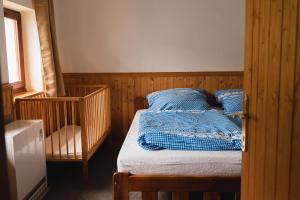 a bedroom with a bed with a blue blanket on it at Roubenka U 2 přátel in Pec pod Sněžkou
