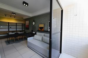 a living room with a couch and a dining room at ESPETACULAR 1 dorm com piscina em Manaíra! in Tambaú