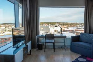 a living room with a desk and a large window at Comfort Hotel Winn in Umeå