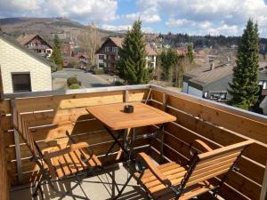 y balcón con mesa y sillas de madera. en BergButzen, en Braunlage