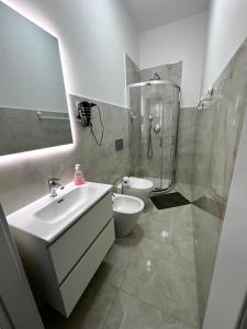 een badkamer met een wastafel, een toilet en een douche bij B&B Corso Italia in Pisa