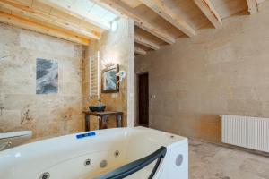 a large bathroom with a tub and a toilet at Tughan Stone House in Uçhisar