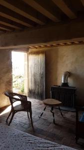 a room with a chair and a table and a stove at La Cabane du Berger in Saint-Didier-sur-Arroux