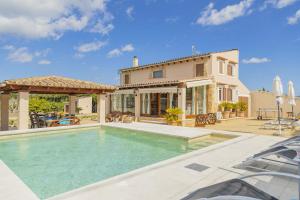 a home with a swimming pool in front of a house at Villa Son Rotger in Alcudia