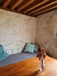 a bedroom with a bed and a table with a vase of flowers at La Cabane du Berger in Saint-Didier-sur-Arroux