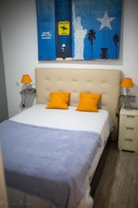 1 dormitorio con 1 cama con 2 almohadas de color naranja en Apartamento La Muralla & Casco histórico, en Córdoba