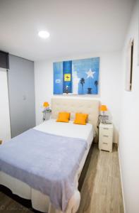 1 dormitorio con 1 cama grande con almohadas de color naranja en Apartamento La Muralla & Casco histórico, en Córdoba