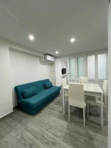 a living room with a blue couch and a table at Monolocale "Sula" in Agropoli