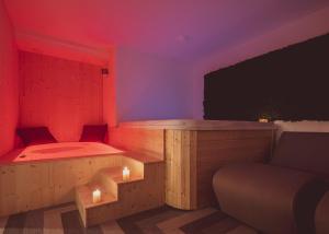 a room with a bed and a couch and a tv at Tramas Hotel & Spa in Olbia