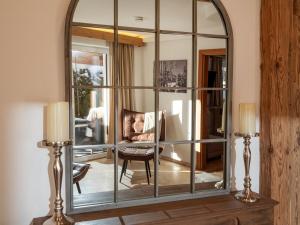 a large mirror in a living room with a couch at Tirol Chalet Brixen in Brixen im Thale
