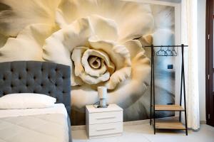 een slaapkamer met een muurschildering van een bloem bij Civico 16 in Saluzzo