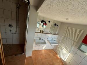 uma casa de banho com 2 lavatórios e um chuveiro em Haus Bade em Stralsund
