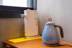 a tea kettle sitting on top of a wooden table at Big K House in Busan