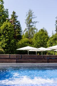 two white umbrellas sitting next to a swimming pool at Soldanella by Hotel Adula in Flims
