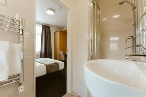 Un baño con bañera y una cama en una habitación. en Star Hotel, en Londres 37 fotos más