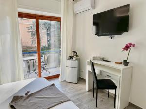 een slaapkamer met een bureau en een tv aan de muur bij Room Center Sorrento Baby in Sorrento