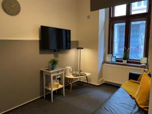 - un salon avec un canapé et une télévision murale dans l'établissement Millenium Apartments, à Cracovie