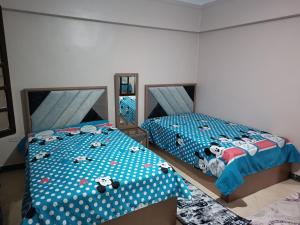 a bedroom with two beds with hello kitty sheets at شقه للايجار مكرم عبيد 1 in Cairo