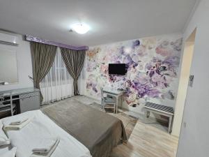 a bedroom with a bed and a desk and a tv at Hotel Dorobanti in Iaşi