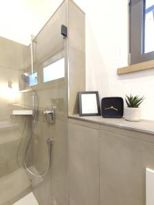 baño con ducha con una foto en la encimera en Fuxbau Waldlounge, en Ruhpolding