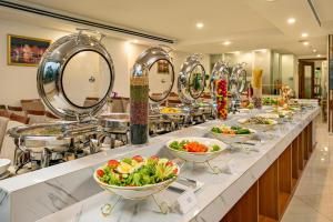 a buffet line with bowls of food and mirrors at Prague Hotel in Da Nang