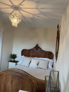 a bedroom with a large wooden bed with a chandelier at Brockwell - 2 Bed Modern Home, Near City Centre in Bowburn