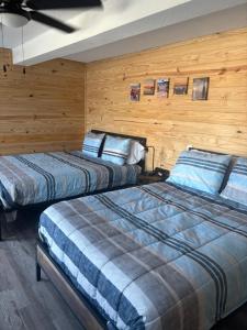 2 camas en una habitación con paredes de madera en Good Times Motel and Marina, en Steinhatchee