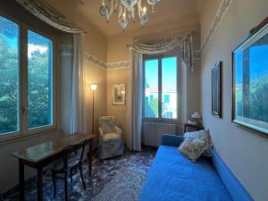 uma sala de estar com uma mesa e um sofá azul em Villa Doria 16Pax Waterfront by VILLASRETREATS em Portovenere