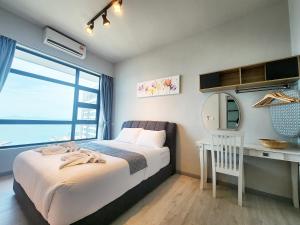 a bedroom with a bed and a desk and a window at Jesselton Quay Kota Kinabalu City Centre by LW Suites in Kota Kinabalu