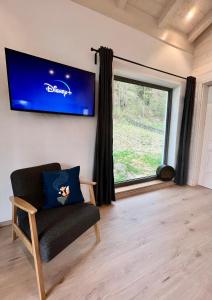 sala de estar con silla y ventana grande en Fuxbau Waldlounge en Ruhpolding