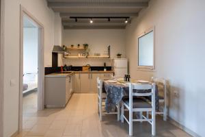 uma cozinha com uma mesa e cadeiras e um frigorífico em Vallia's Seaview & Stylish Apartments by Konnect, Nisaki em Nisakion