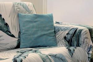 Un sofá azul y blanco con una almohada. en Casa mare Levanto 1, en Levanto