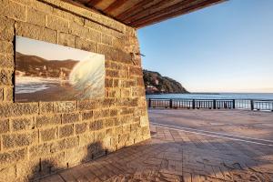 una pared de ladrillo con una imagen de playa en Casa mare Levanto 1, en Levanto
